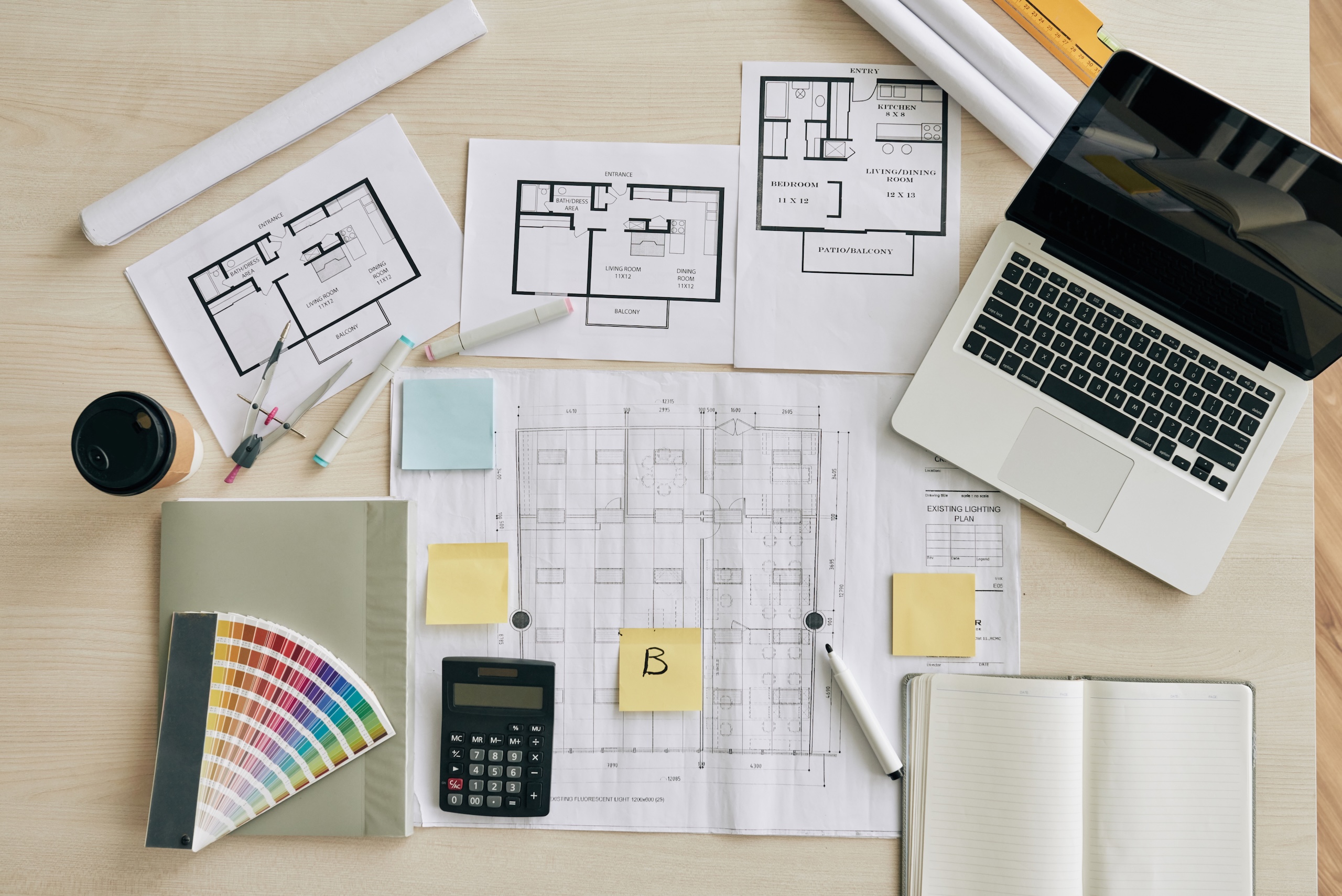 Plans and blueprints on table of interior designer, view from above